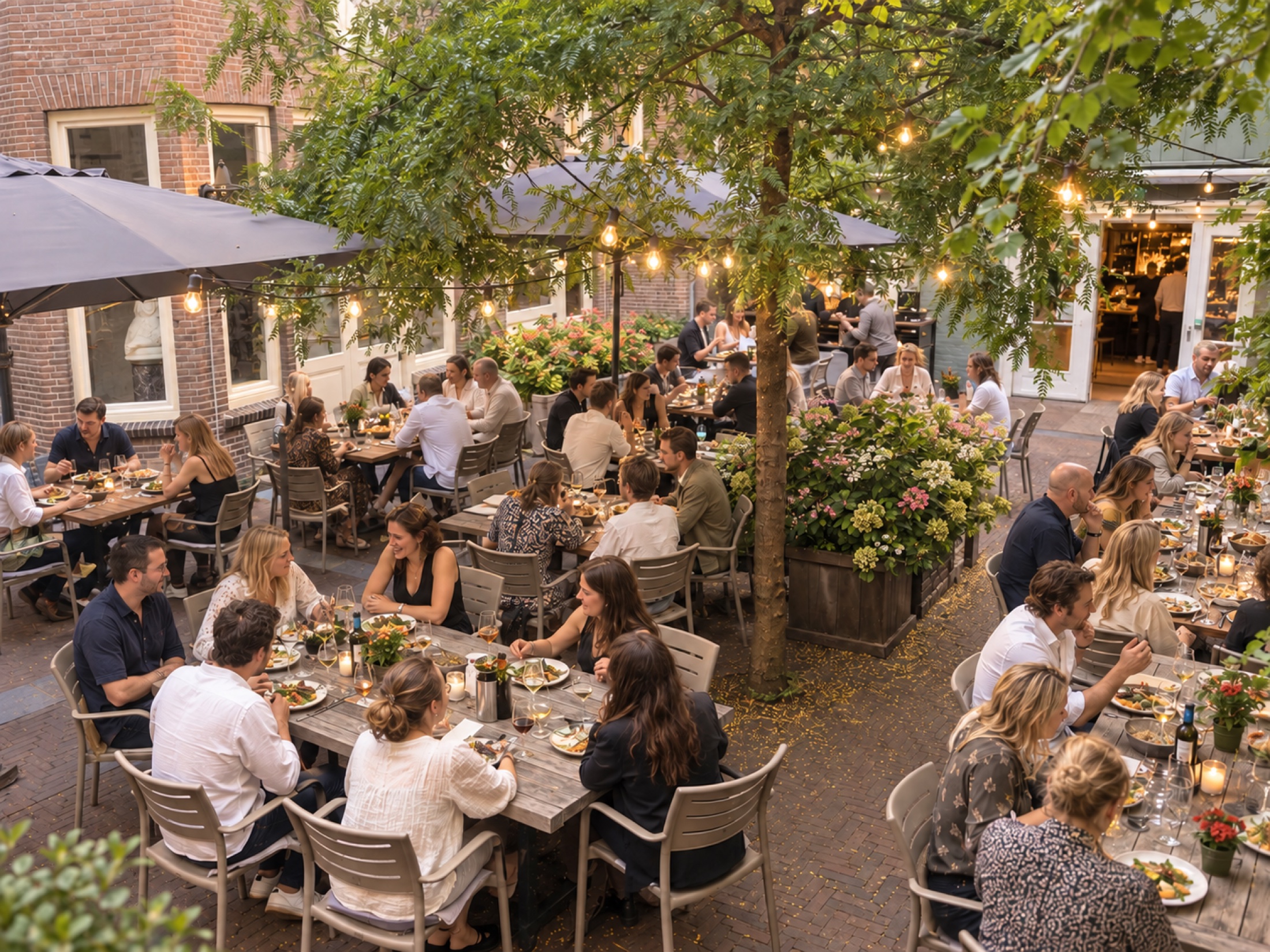 Gasten aan tafel in de sfeervolle binnentuin van Café Restaurant Pulchri